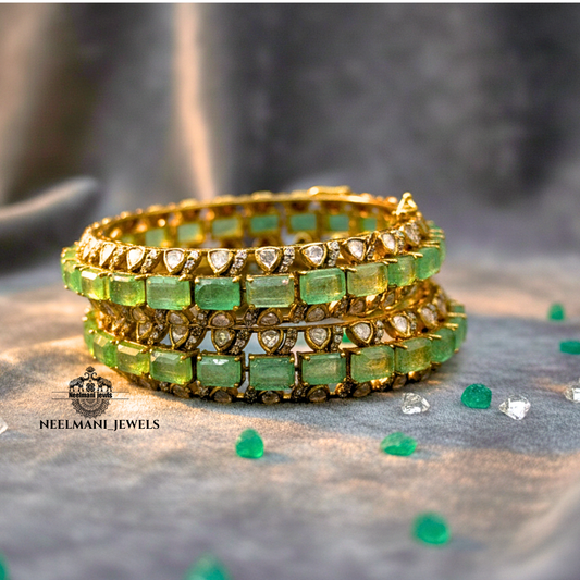 Gold and green gemstone bracelet on a textured surface with 'Neelmani Jewels' branding.