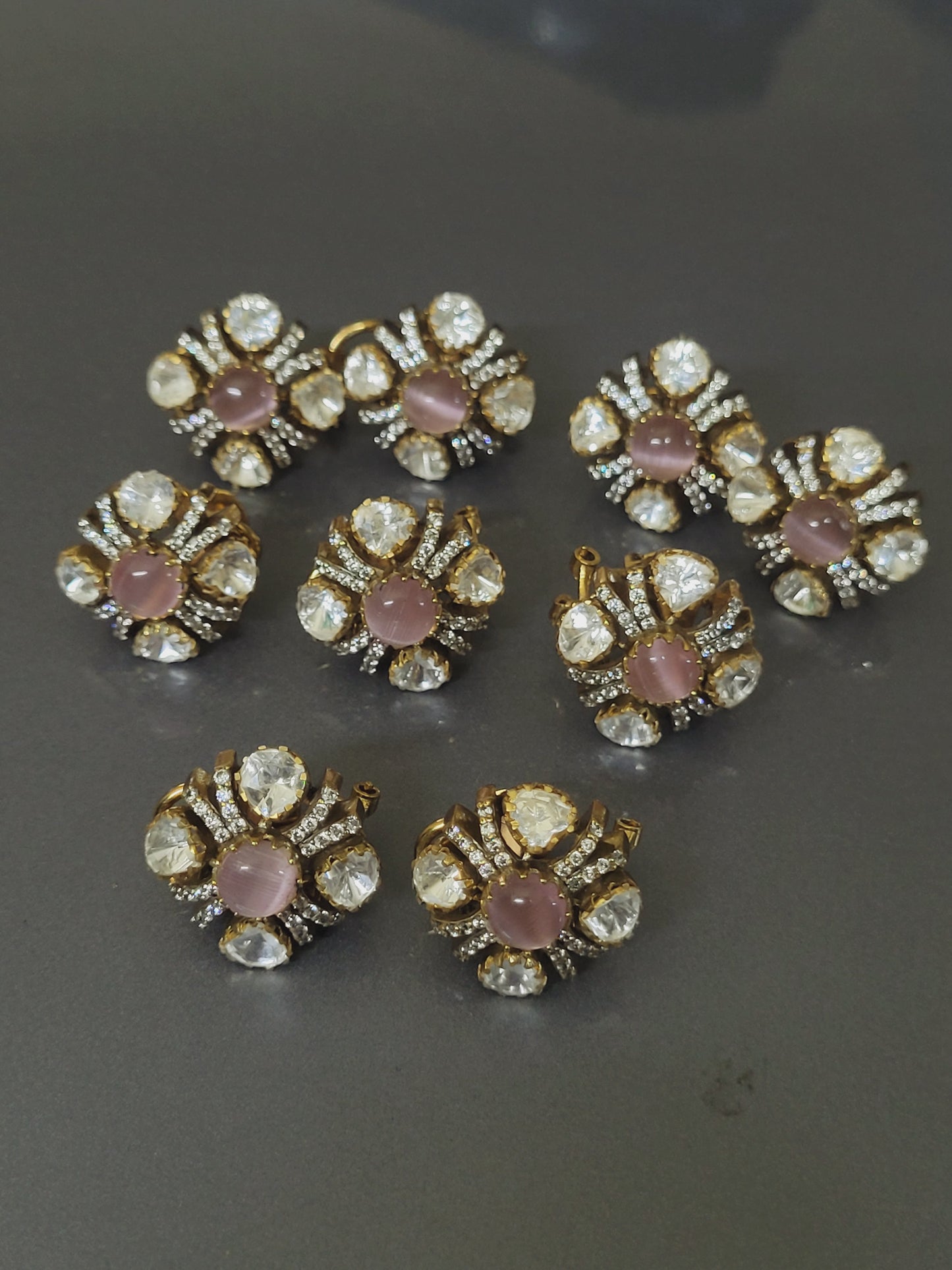 Decorative flower-shaped embellishments with pink centers and gold accents on a dark background