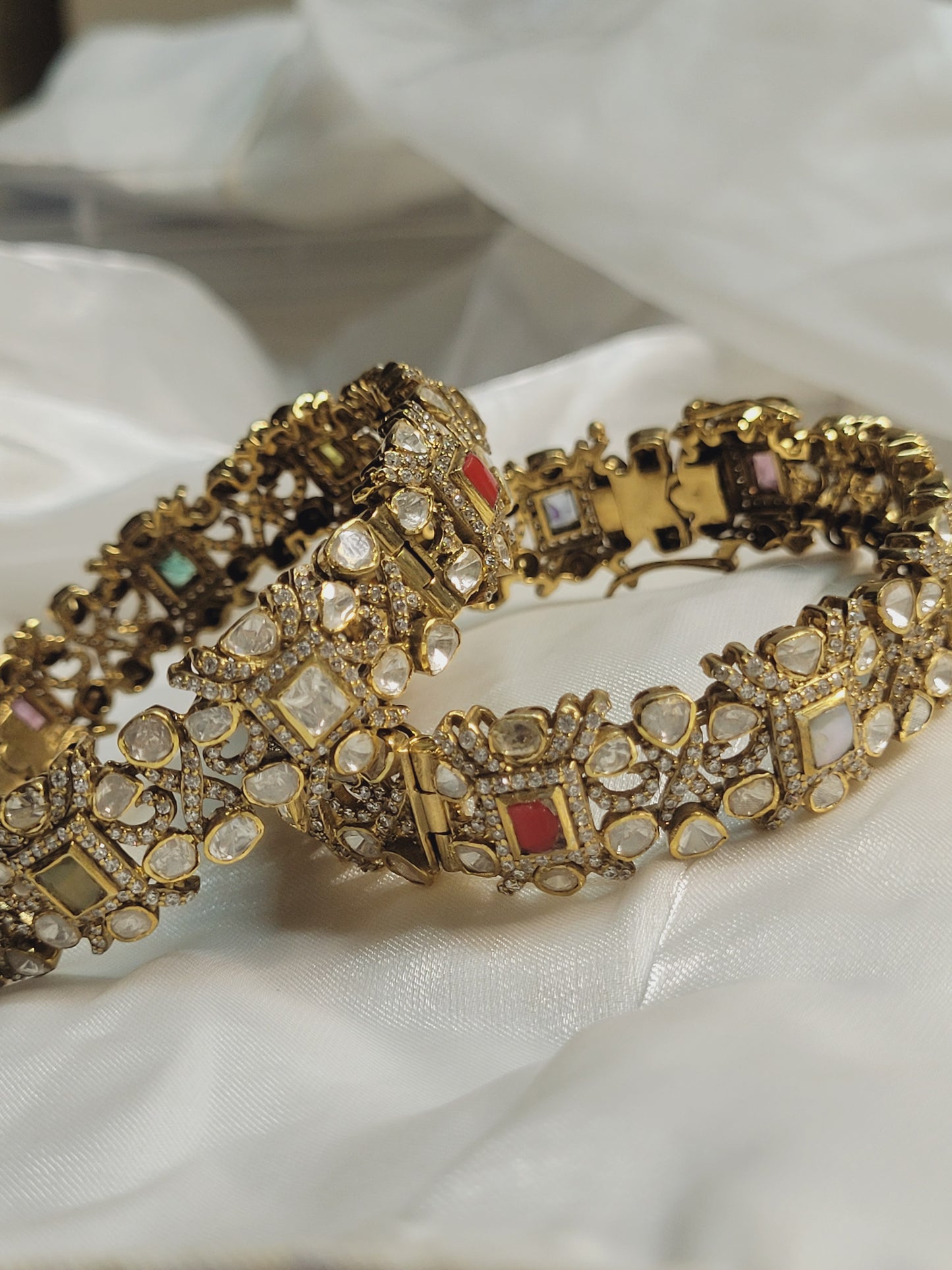 Designer gold kada bangles studded with crystals and stones, ethnic bridal jewellery accessory on soft white cloth