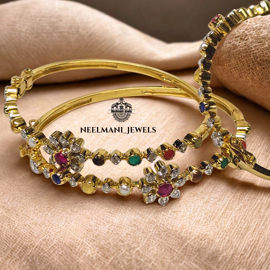 Gold bangles with gemstones on a beige fabric, featuring Neelmani Jewels logo.