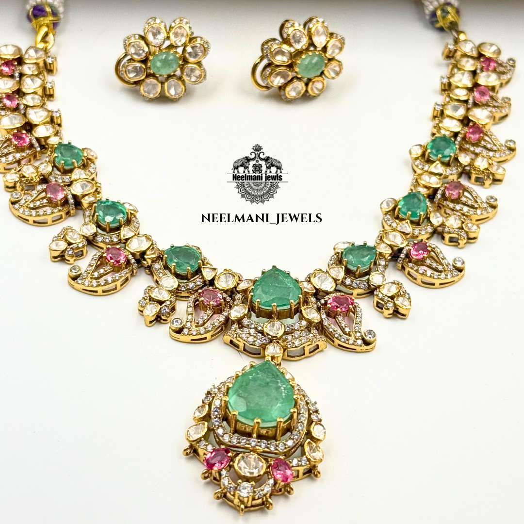 Necklace and earrings with green and pink gemstones on a white background, featuring Neelmani Jewels logo.