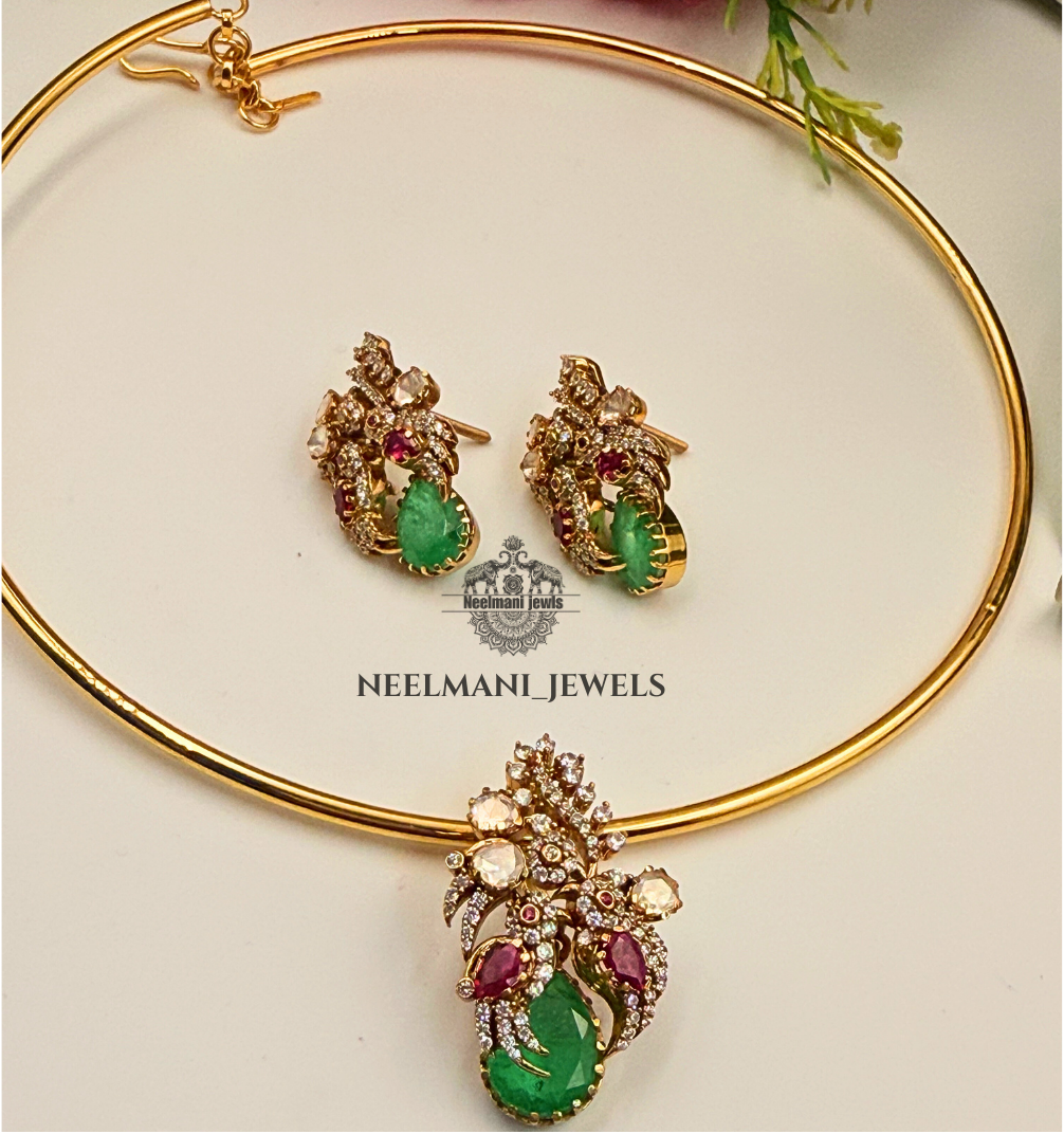 Gold jewelry set with green and red gemstones on a white background, featuring Neelamani Jewels logo.