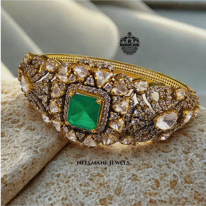 Gold bracelet with a green gemstone , branded 'Neelemani Jewels'.