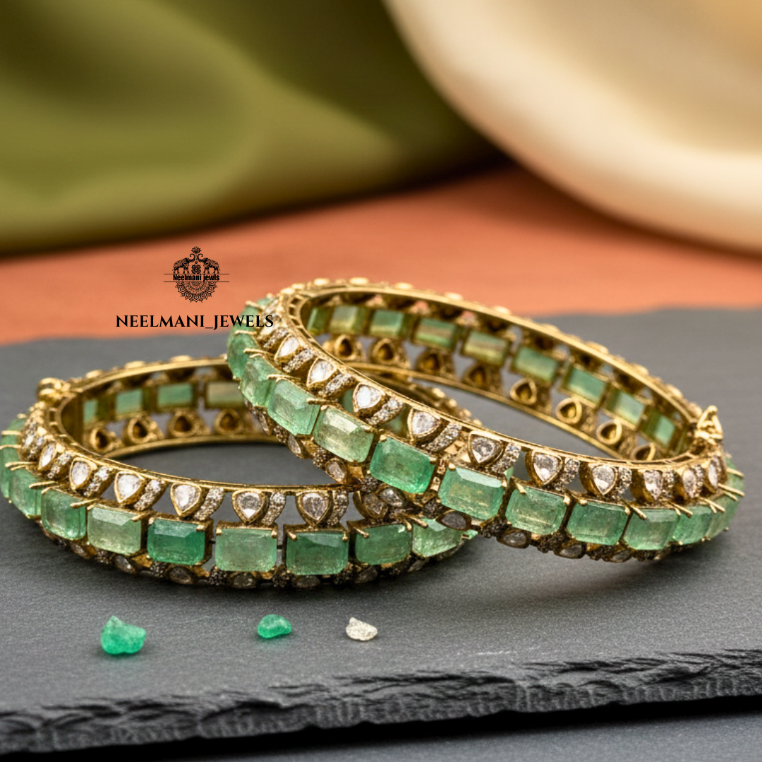 Gold and green gemstone bangles on a dark surface with Neelemani Jewels logo.